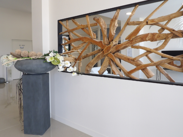 Détail de la cloison décorative en bois flotté en étoile sur cadre miroir et vasque de fleurs, chambre funéraire à Betton